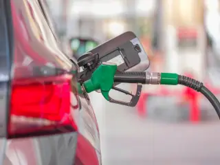 Ilustrasi: Nozel bahan bakar hijau sedang mengisi tangki bensin mobil.
