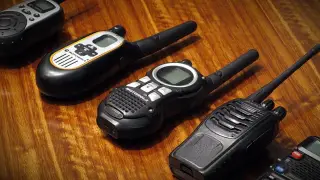 Ilustrasi: Beberapa walkie-talkie tergeletak di atas permukaan meja kayu.