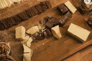 Ilustrasi: Potongan cokelat putih dan cokelat hitam tersaji di atas meja kayu.