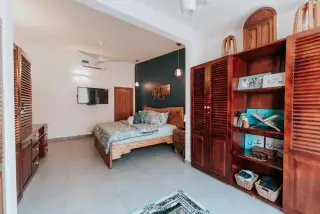 Ilustrasi: Kamar tidur berukuran luas dengan perabot kayu, tempat tidur tertata rapi, dan lemari.